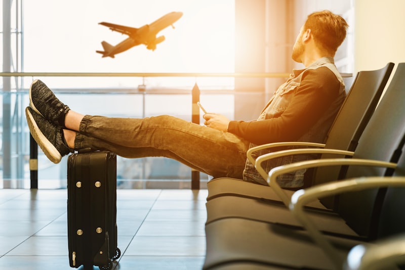 An open backpack and travel essentials laid out on a wooden floor before a long trip